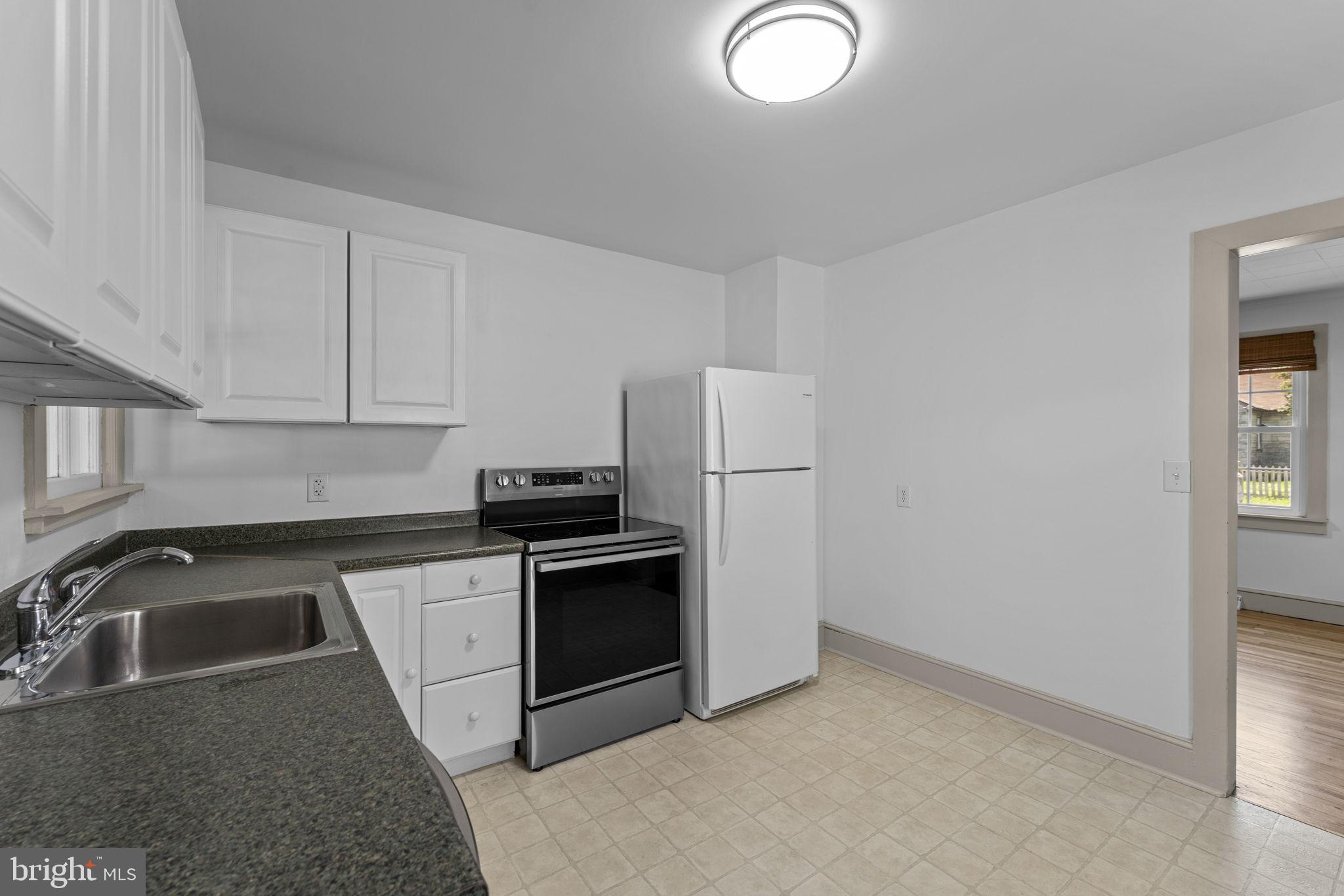 216 Walnut Street Berryville, VA 22611 - Photo 23 of 36 a kitchen with granite countertop a sink a stove a refrigerator a window and cabinetry