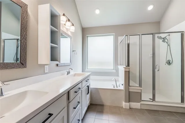 a bathroom with a double vanity sink a mirror and a bathtub