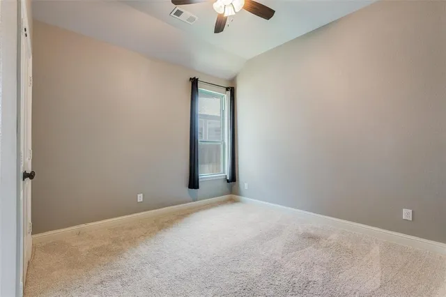 an empty room with chandelier fan