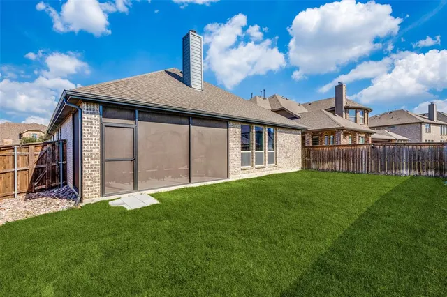 a view of a house with a yard and a large tree
