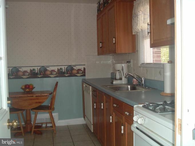 5553 Gayland Road Halethorpe, MD 21227 - Photo 4 of 12 a kitchen with stainless steel appliances granite countertop a sink stove and cabinets