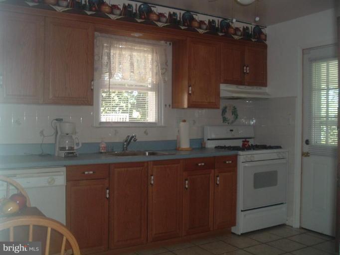 5553 Gayland Road Halethorpe, MD 21227 - Photo 5 of 12 a kitchen with granite countertop a sink stove and cabinets