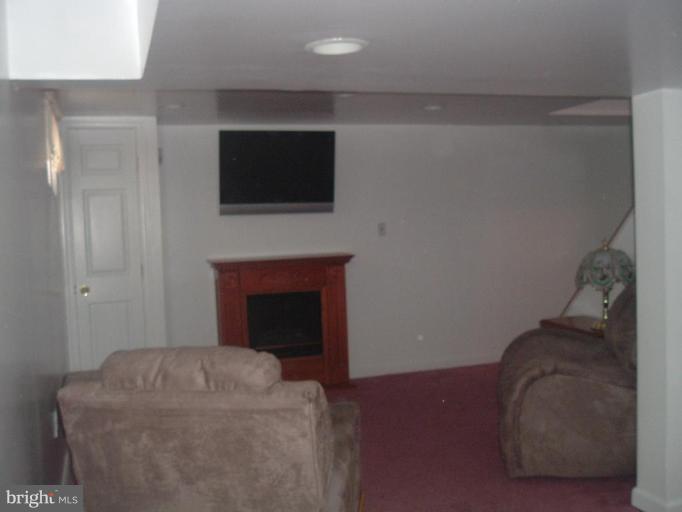 5553 Gayland Road Halethorpe, MD 21227 - Photo 6 of 12 a living room with a fireplace and a flat screen tv