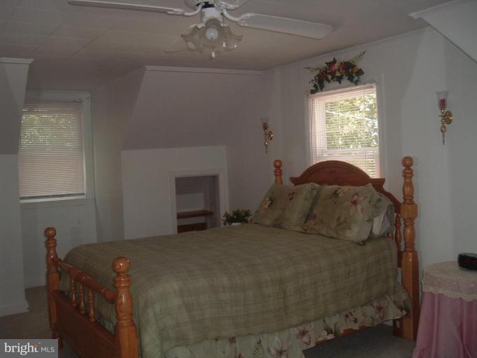 5553 Gayland Road Halethorpe, MD 21227 - Photo 9 of 12 a bed sitting in a bedroom next to a window and a chandelier