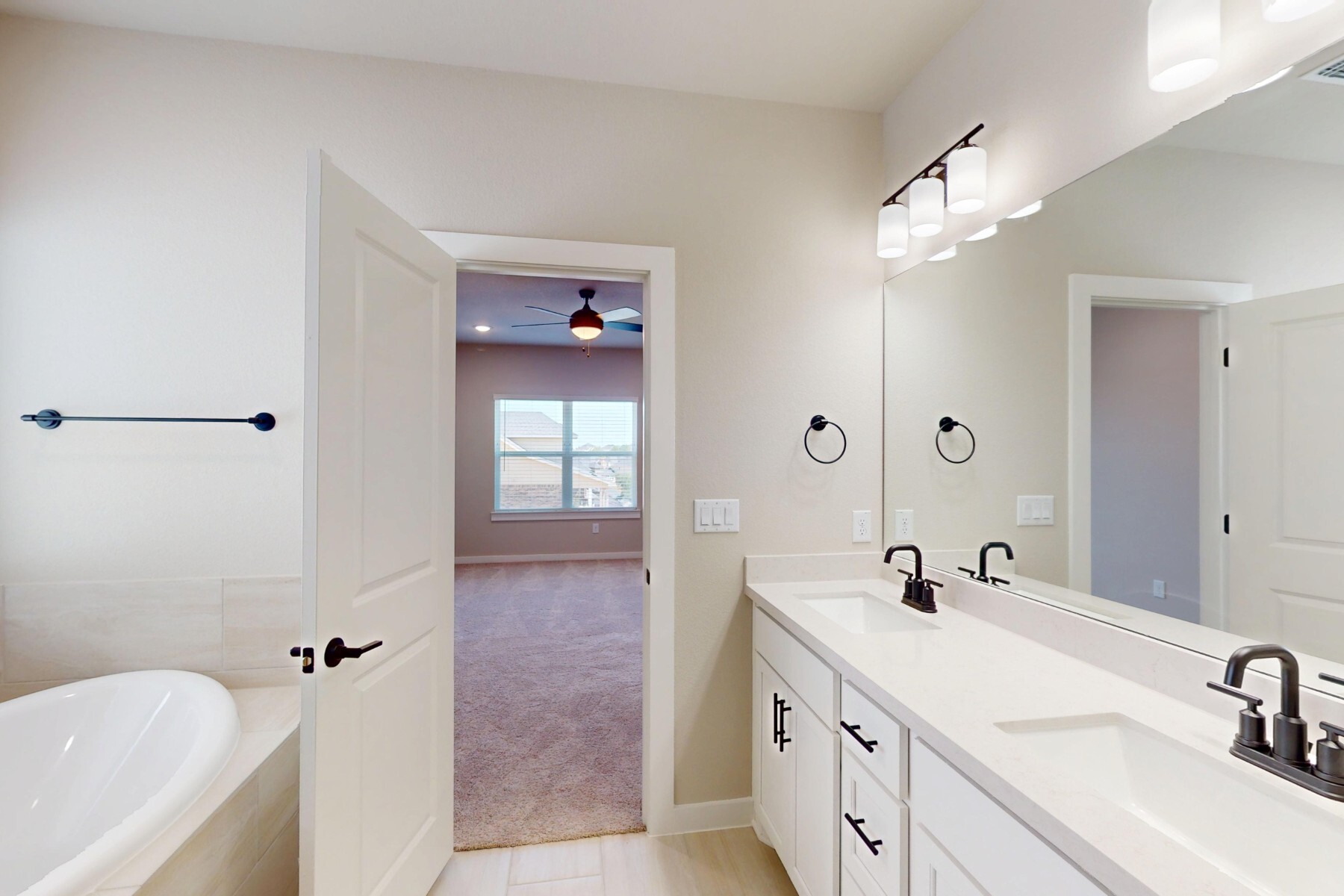 3679 Prosper Road Leander, TX 78641 - Photo 28 of 40 a bathroom with a double vanity sink a mirror a bathtub and shower