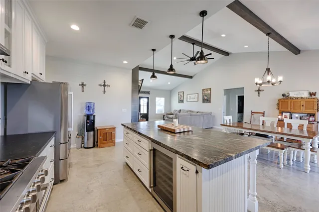 a large kitchen with kitchen island white cabinets and stainless steel appliances