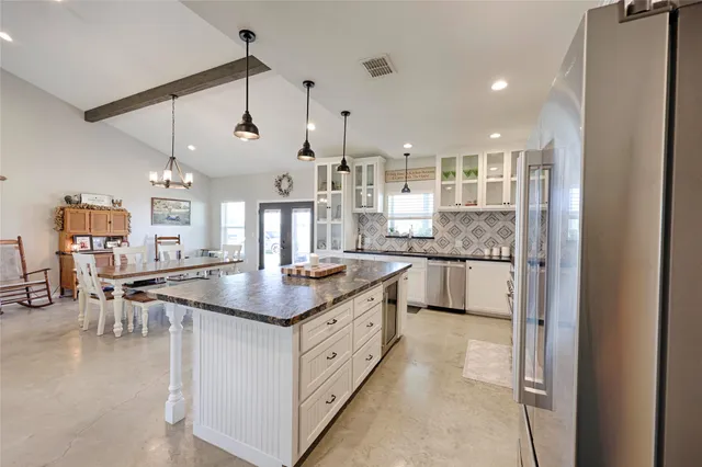 a kitchen with stainless steel appliances granite countertop a refrigerator and a sink