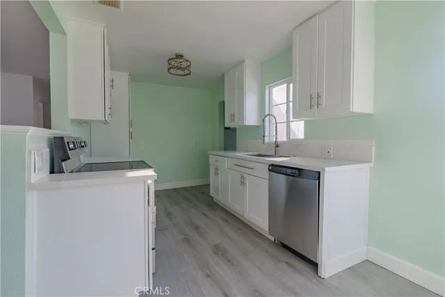 a kitchen with a sink cabinets and wooden floor
