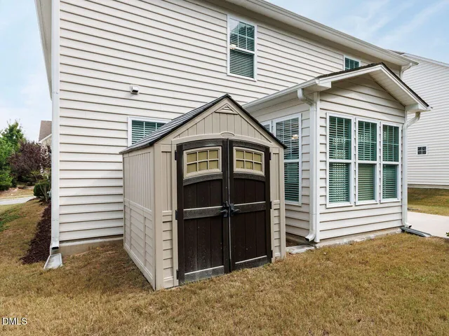 a view of a road with a yard and a large tree