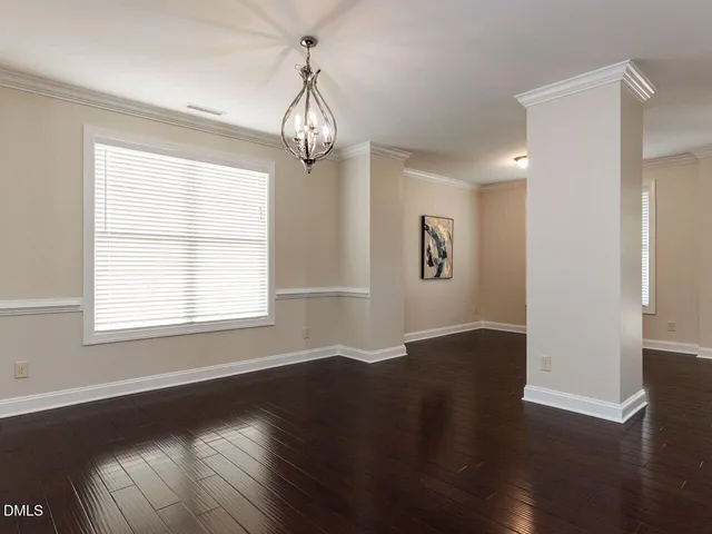 a view of empty room with wooden floor and window
