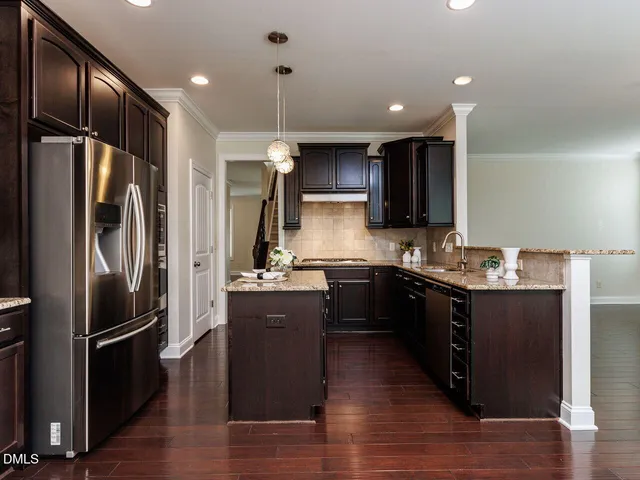 a kitchen with kitchen island granite countertop stainless steel appliances and wooden cabinets