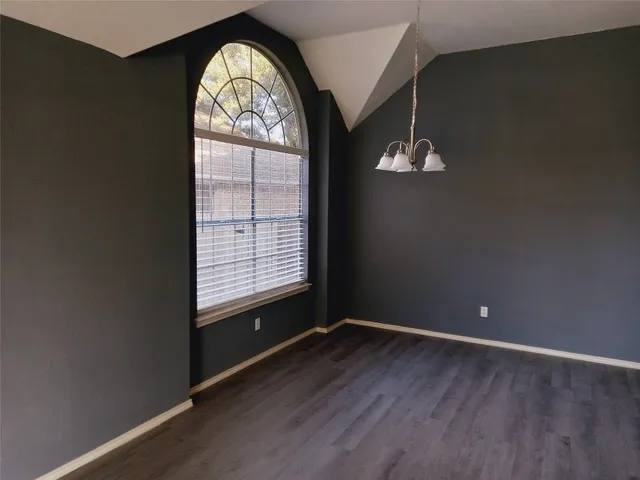 a view of empty room with wooden floor and fireplace