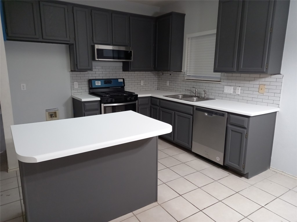 2018 Old Mill Road Cedar Park, TX 78613 - Photo 21 of 22 a kitchen with stainless steel appliances a sink a stove a microwave a sink and cabinets
