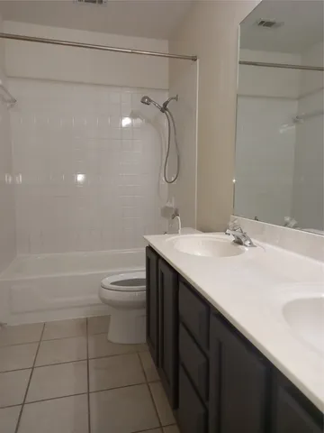 a bathroom with a granite countertop sink a toilet and shower
