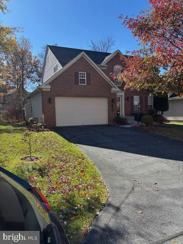 a front view of house with yard and trees in the background