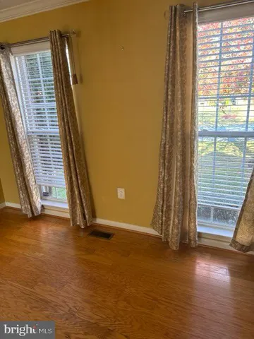 a view of a room with wooden floor and windows