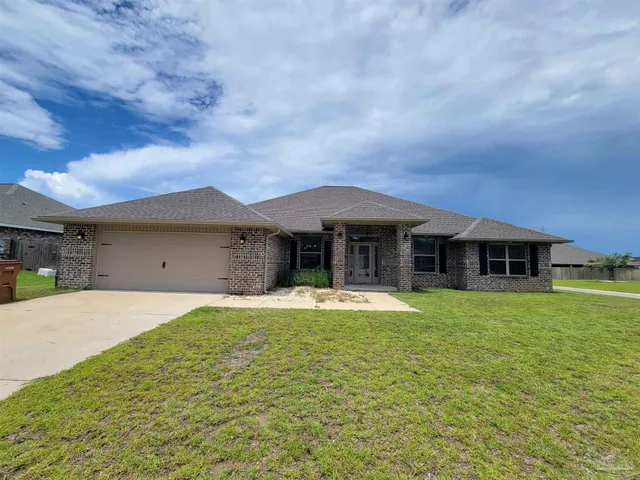 a front view of a house with a garden and yard