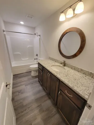 a bathroom with a granite countertop sink a mirror and a bathtub