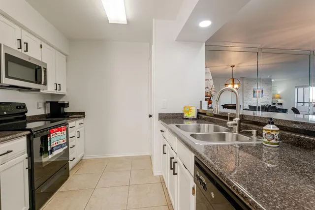 a kitchen with stainless steel appliances granite countertop a sink a stove and a microwave