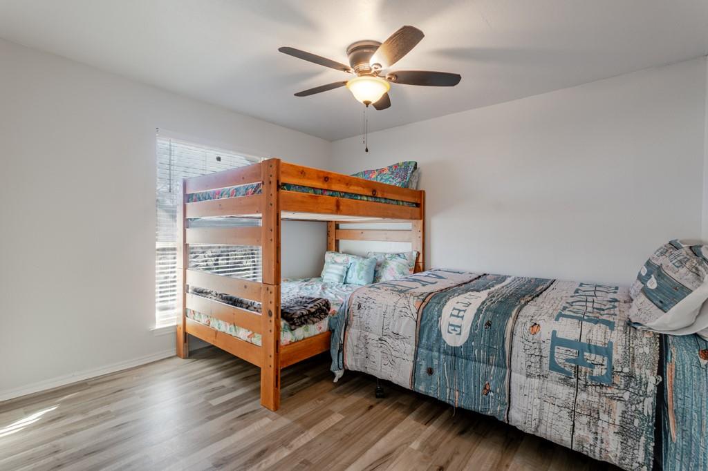 3107 Hells Gate Loop, Unit B62 Strawn, TX 76475 - Photo 16 of 24 a bedroom with a bed and a chandelier