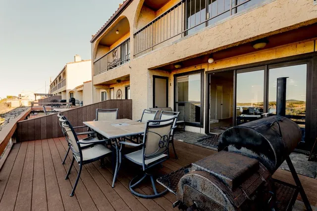 a view of a patio with table and chairs with wooden floor and fence