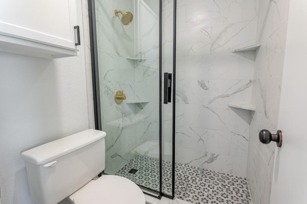 3107 Hells Gate Loop, Unit B62 Strawn, TX 76475 - Photo 5 of 24 a bathroom with a toilet and a shower