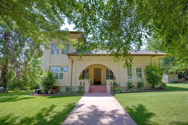 a front view of a house with a garden and plants