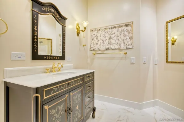 a bathroom with a granite countertop double vanity and a mirror