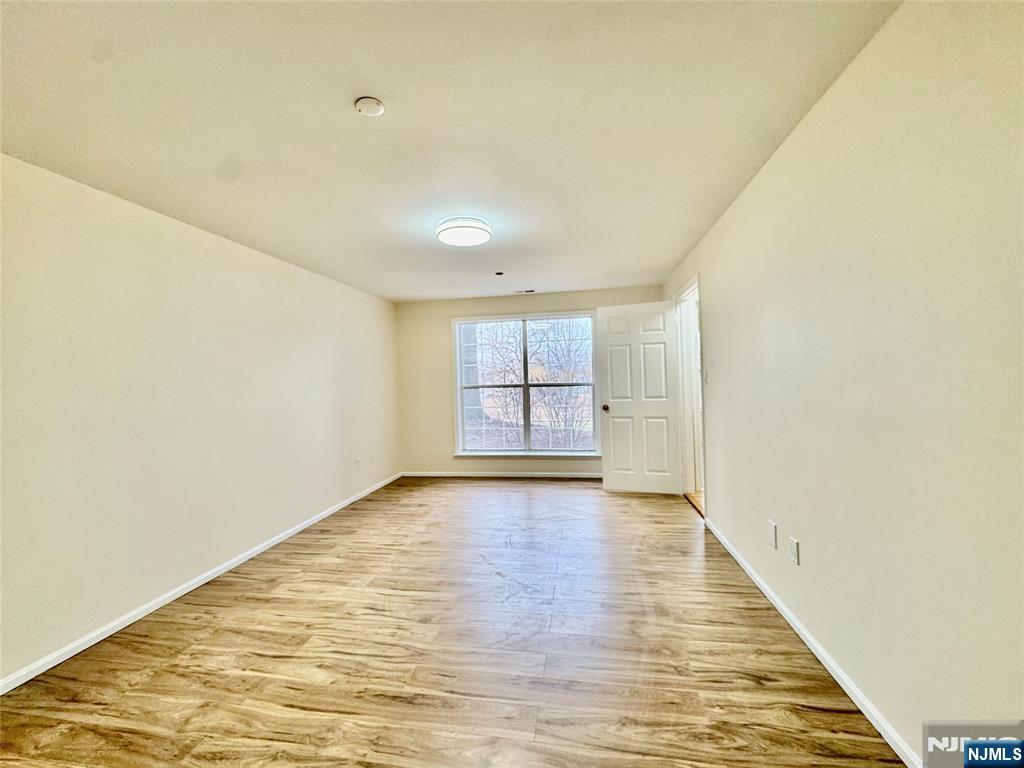 22 Regency Circle Englewood, NJ 07631 - Photo 12 of 21 a view of an empty room with window and wooden floor