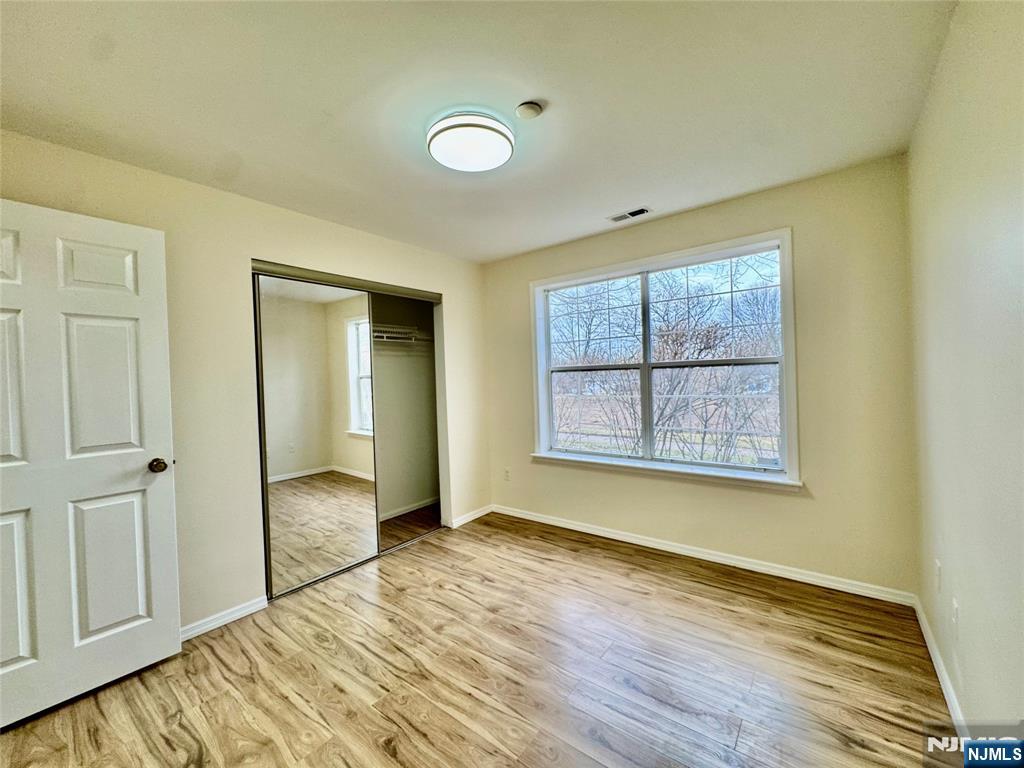 22 Regency Circle Englewood, NJ 07631 - Photo 16 of 21 an empty room with wooden floor closet and windows