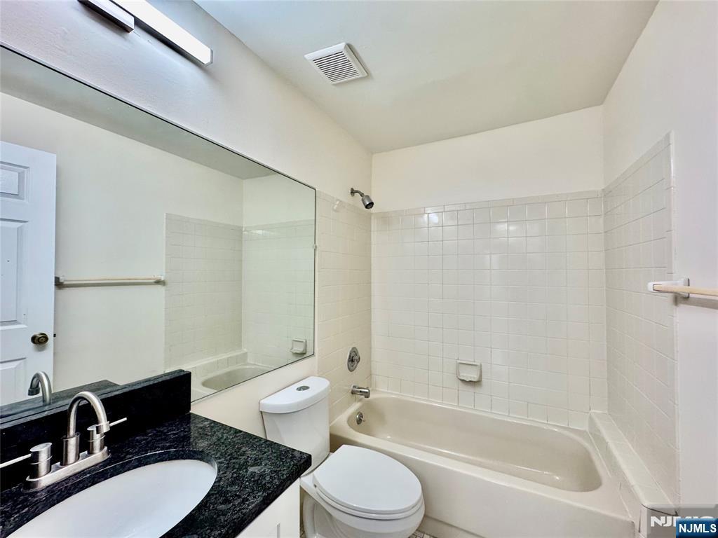 22 Regency Circle Englewood, NJ 07631 - Photo 17 of 21 a bathroom with a granite countertop sink toilet a mirror and shower