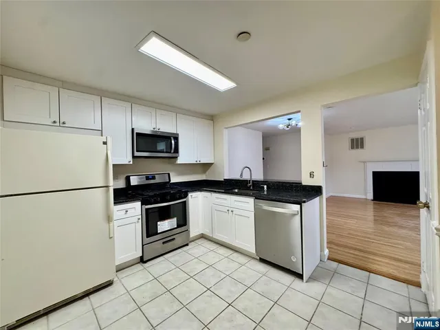 a kitchen with stainless steel appliances granite countertop a refrigerator and a stove top oven
