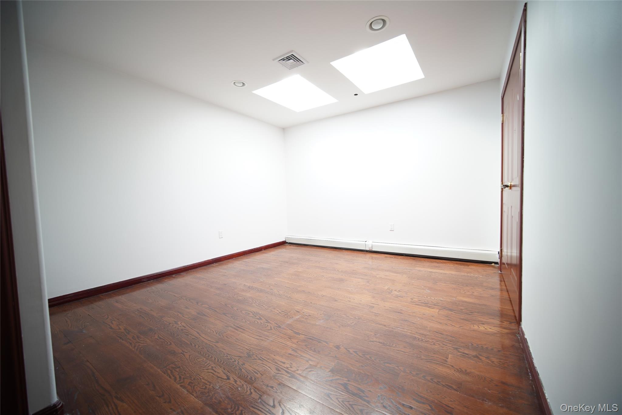 931 East 215th Street, Unit 2 Bronx, NY 10469 - Photo 10 of 16 an empty room with wooden floor and fan