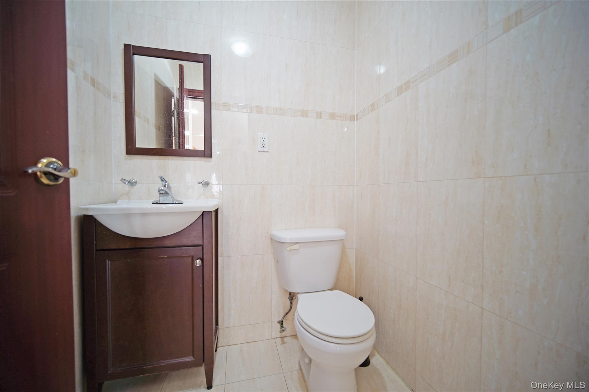 931 East 215th Street, Unit 2 Bronx, NY 10469 - Photo 6 of 16 a bathroom with a sink a toilet and mirror
