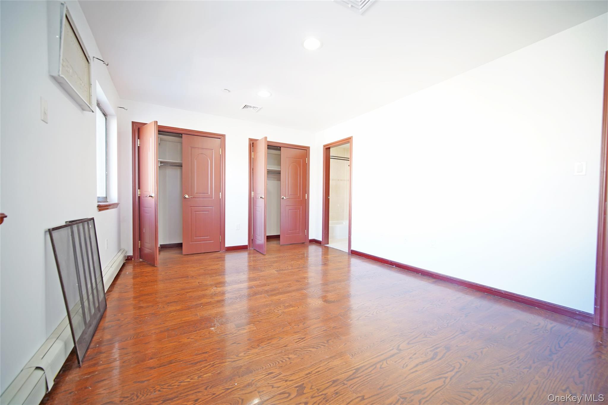 931 East 215th Street, Unit 2 Bronx, NY 10469 - Photo 7 of 16 a view of an empty room with wooden floor and a window