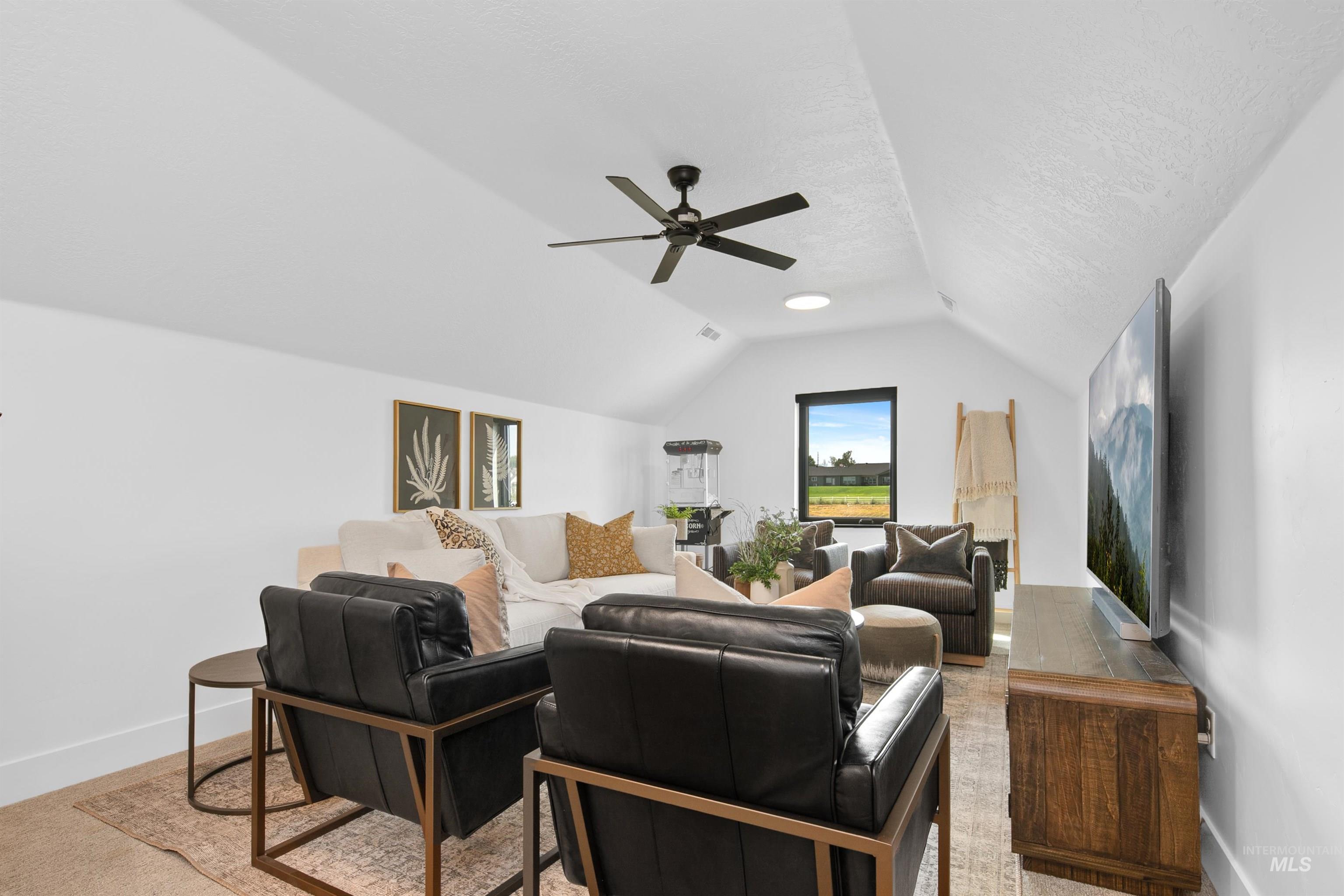 23910 Timber Hls Road Caldwell, ID 83607 - Photo 37 of 50 Living room with lofted ceiling, a ceiling fan, and a textured ceiling