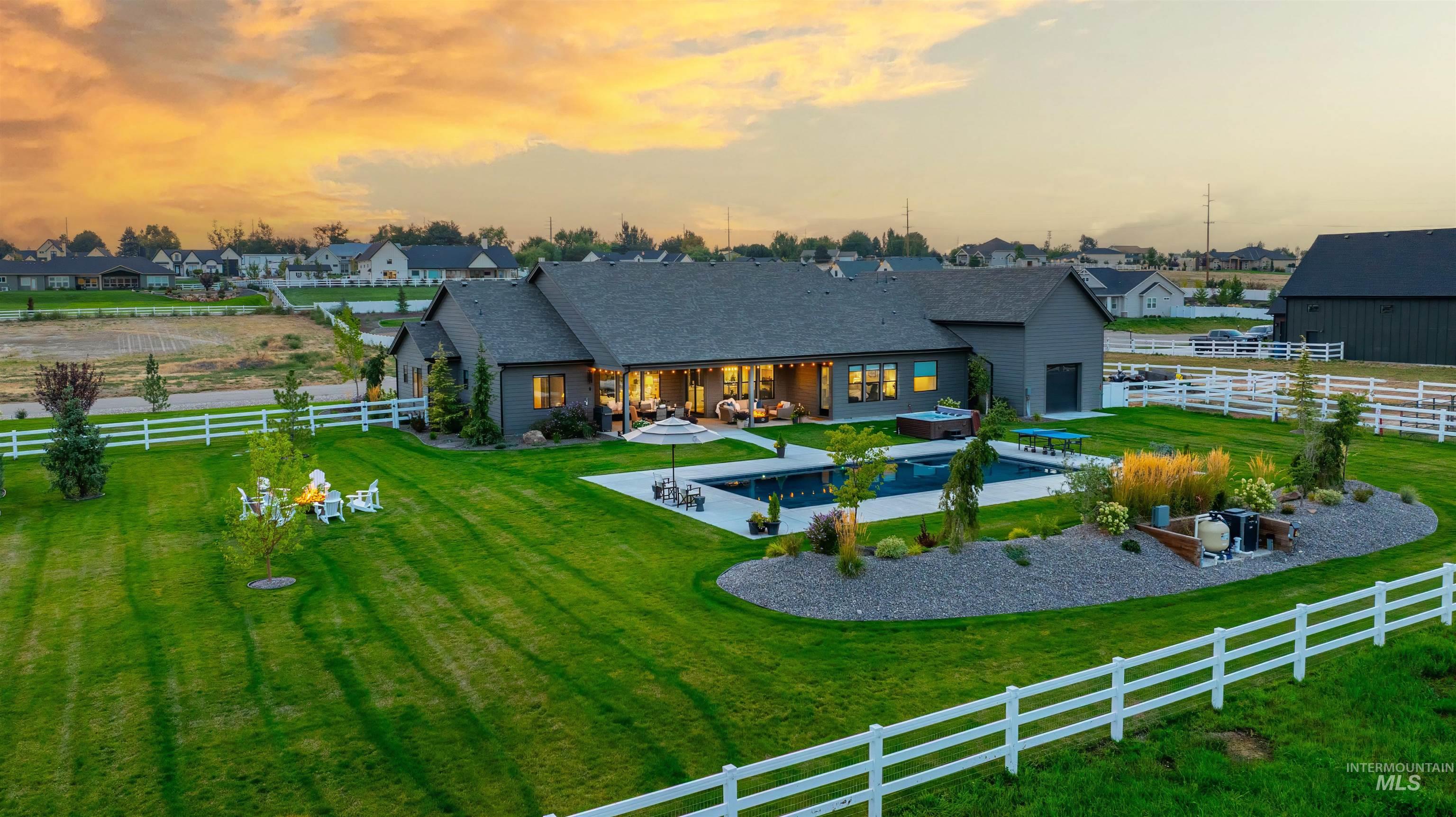 23910 Timber Hls Road Caldwell, ID 83607 - Photo 45 of 50 Back of property with a fenced backyard, a patio, an outdoor pool, a residential view, and a shingled roof