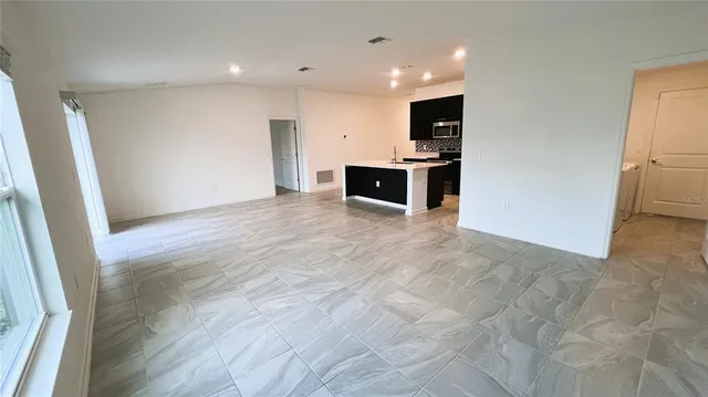 a view of kitchen with microwave and refrigerator