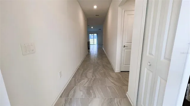 a view of a hallway with wooden floor and entryway