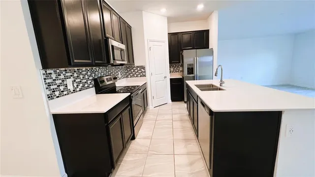 a kitchen with stainless steel appliances a sink stove and refrigerator