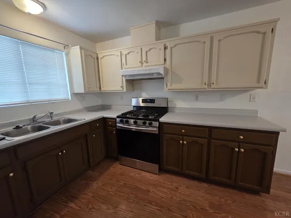 a kitchen with granite countertop a sink cabinets and stainless steel appliances
