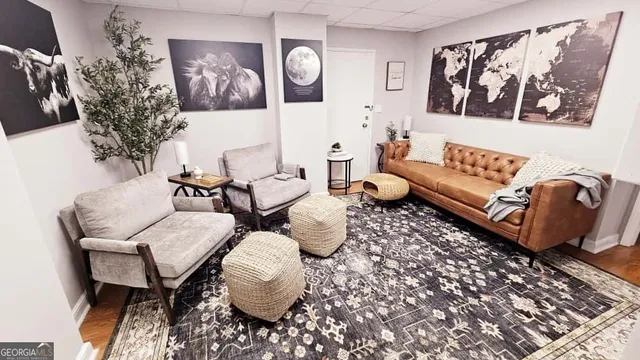 a living room with furniture and wall paintings