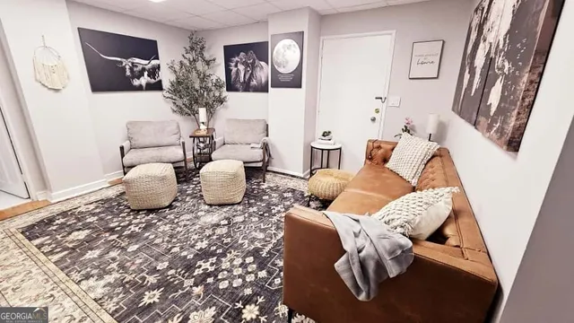 a living room with furniture and a painting on the wall