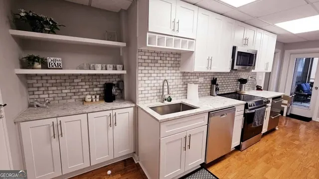 a kitchen with white cabinets a sink and appliances