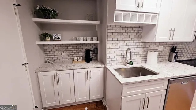a kitchen with white cabinets and sink