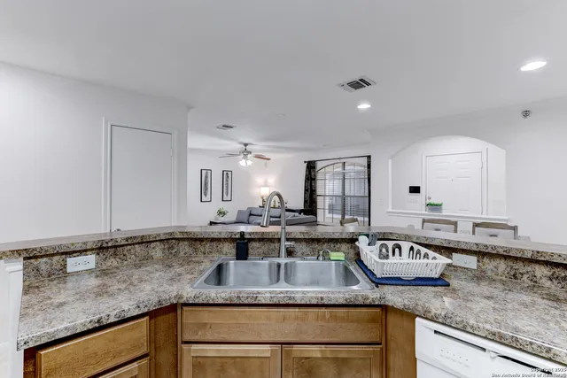 a kitchen with stainless steel appliances granite countertop a sink and a white cabinets