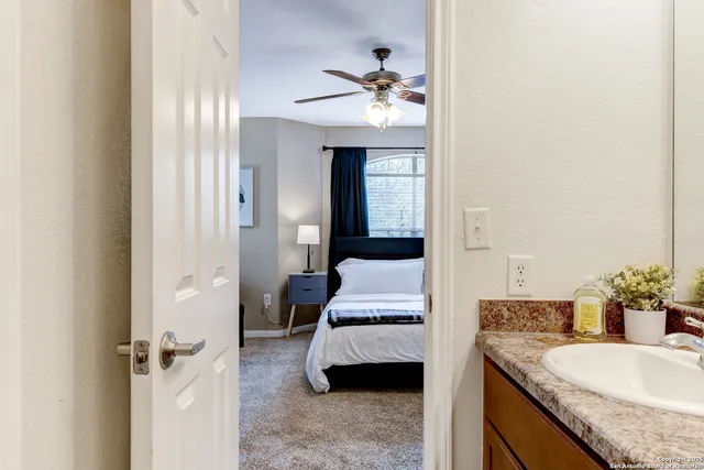a en suite bathroom with a granite countertop sink and a mirror