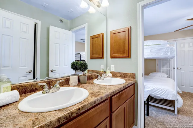 a en suite bathroom with a granite countertop sink and a mirror