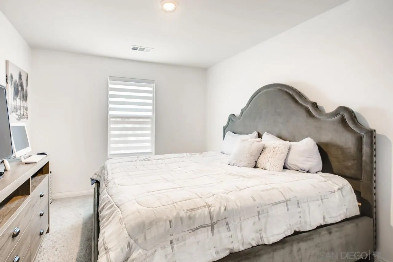 10633 Busch Street Spring Valley, CA 91978 - Photo 20 of 28 a large bed sitting in a bedroom next to a window and a dresser