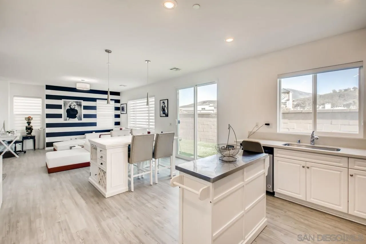 10633 Busch Street Spring Valley, CA 91978 - Photo 10 of 28 a large white kitchen with a large window a sink and a counter space
